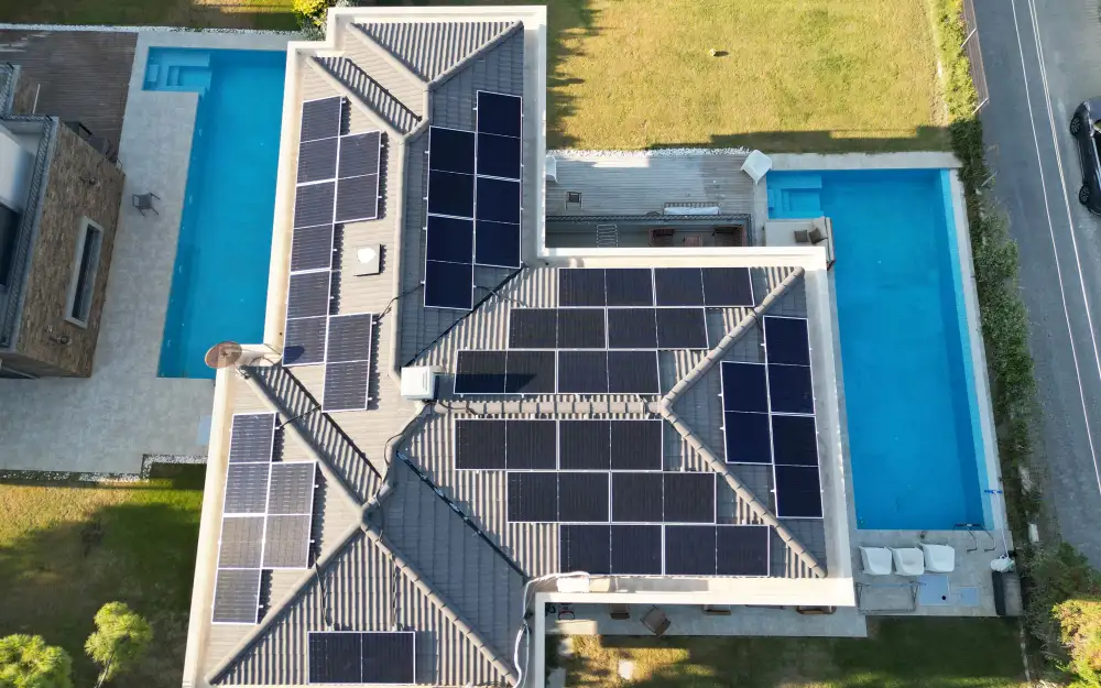 Havuzlu müstakil evin çatısında güneş enerjisi sistemi — drone görüntüsü